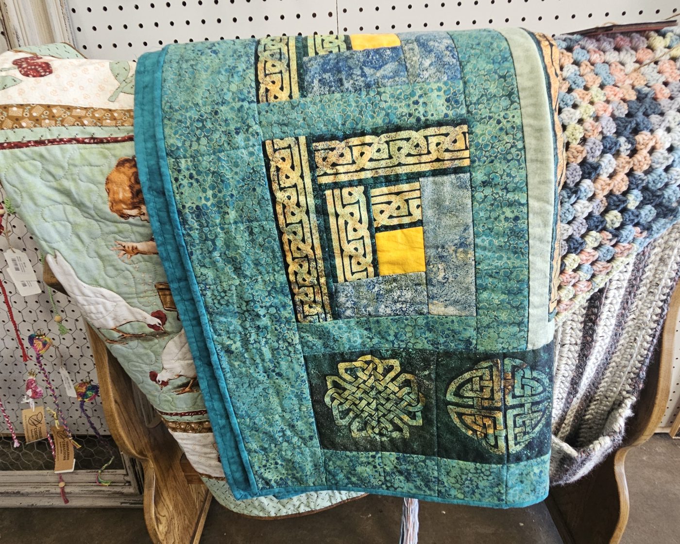 Handmade quilts and woven textiles folded on display shelves